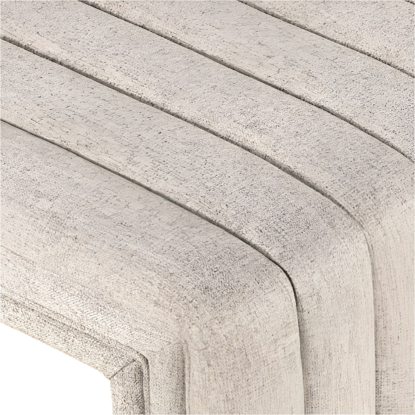 Close-up of natural beige boucle fabric on a curved, channel-stitched end-of-bed bench highlighting textured upholstery and a rounded corner.