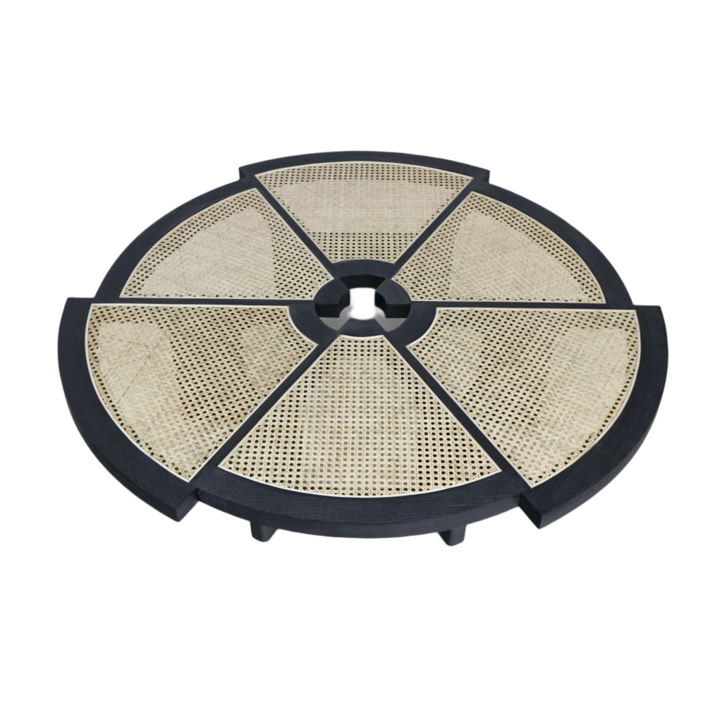 Round modern coffee table with a black wood frame and six natural cane-woven wedge panels radiating from a central circular opening, shown from above.