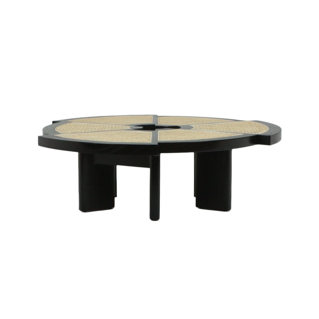 Low round coffee table with a black wooden frame and segmented natural cane inlay top divided into wedge panels, supported by thick black legs on a white background.