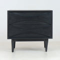 Front view of a mid-century modern solid wood nightstand in smoked black finish, with two sculpted drawers featuring curved recessed fronts and tapered legs on a plain white studio background.
