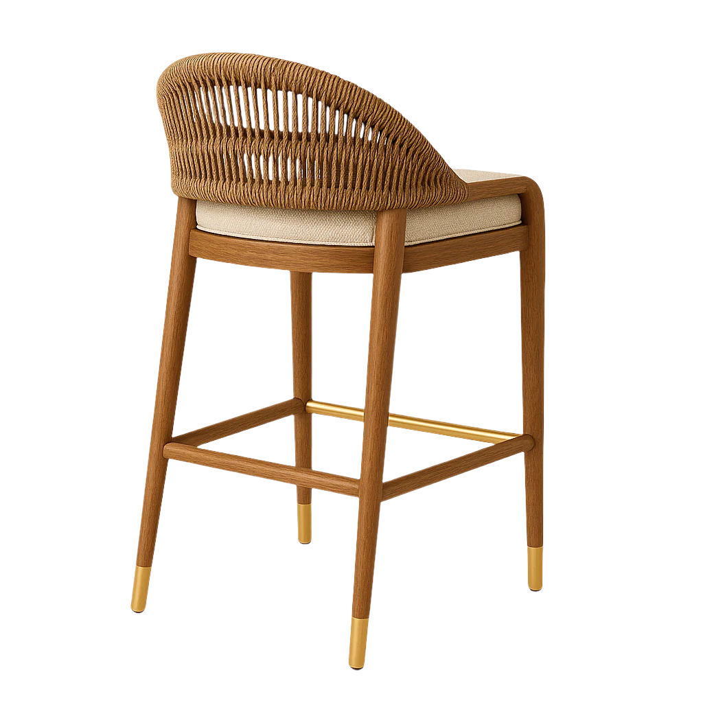 Three-quarter rear view of a teak wood bar stool with a curved woven rope back, beige upholstered seat cushion, and brass footrest and leg caps in a natural brown finish on white background.